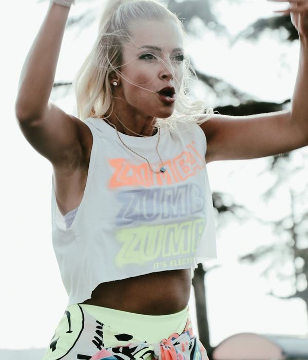 Woman performing a dynamic cardio movement in a bright studio.